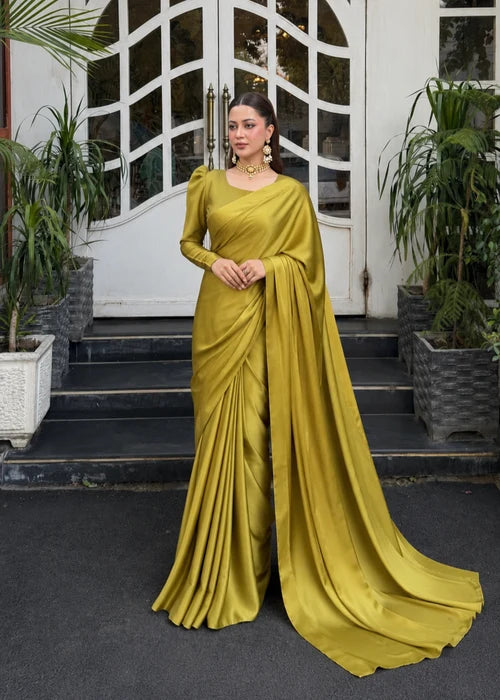 Woman draped in mustard green satin saree with puff sleeve blouse, front view