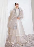 Woman wearing a white traditional outfit with a sheer dupatta on a white background