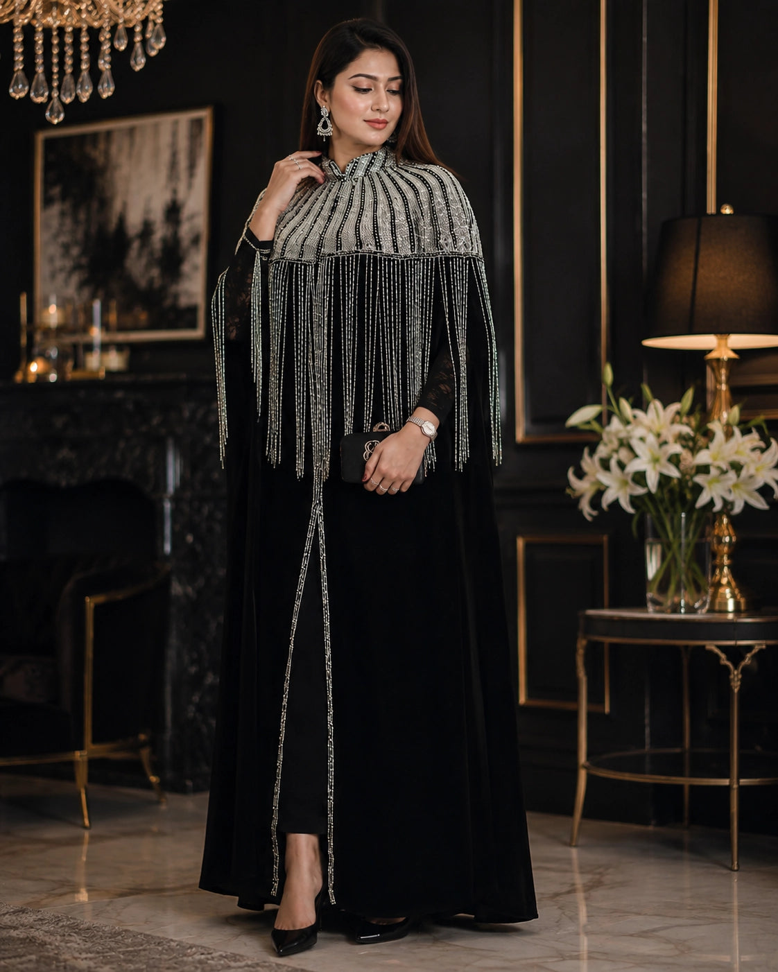 Woman wearing black silk gown with silver fringe embellished cape