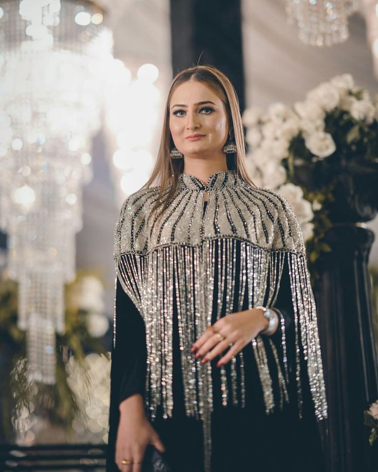 Silver beaded fringe cape detail on black evening gown, close-up