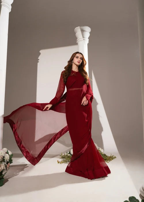 Woman wearing red mermaid evening gown with sheer flowy sleeves