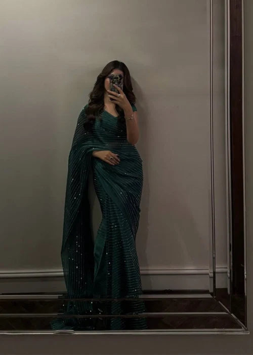 Woman wearing emerald green sequin shimmer saree with matching blouse